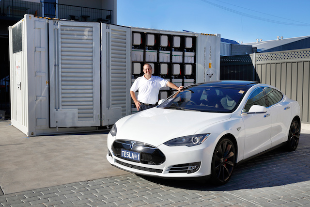 Simon Hackett with his Tesla Model S in front of the Redflow LSB